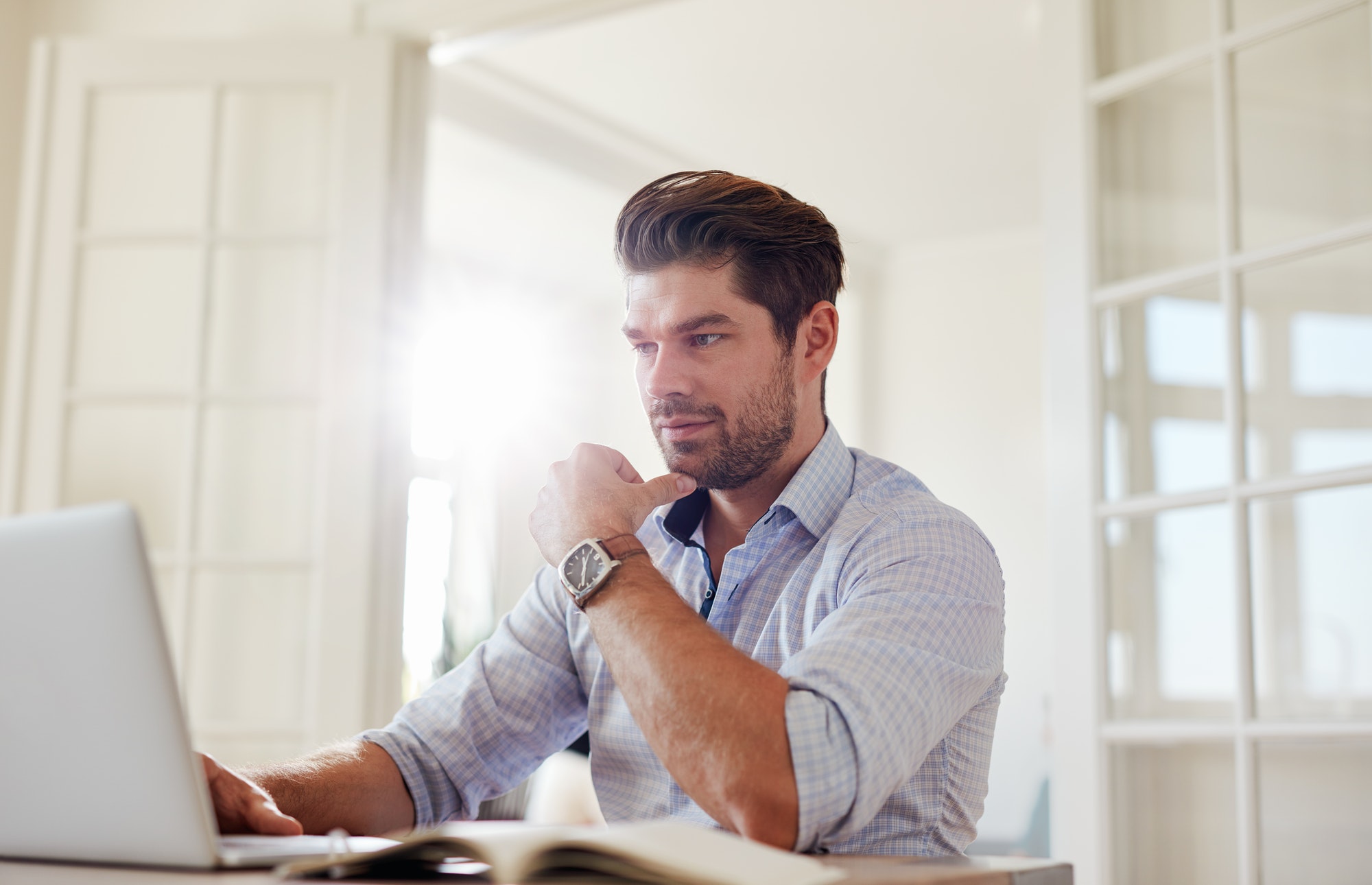 Young man at home working on laptop